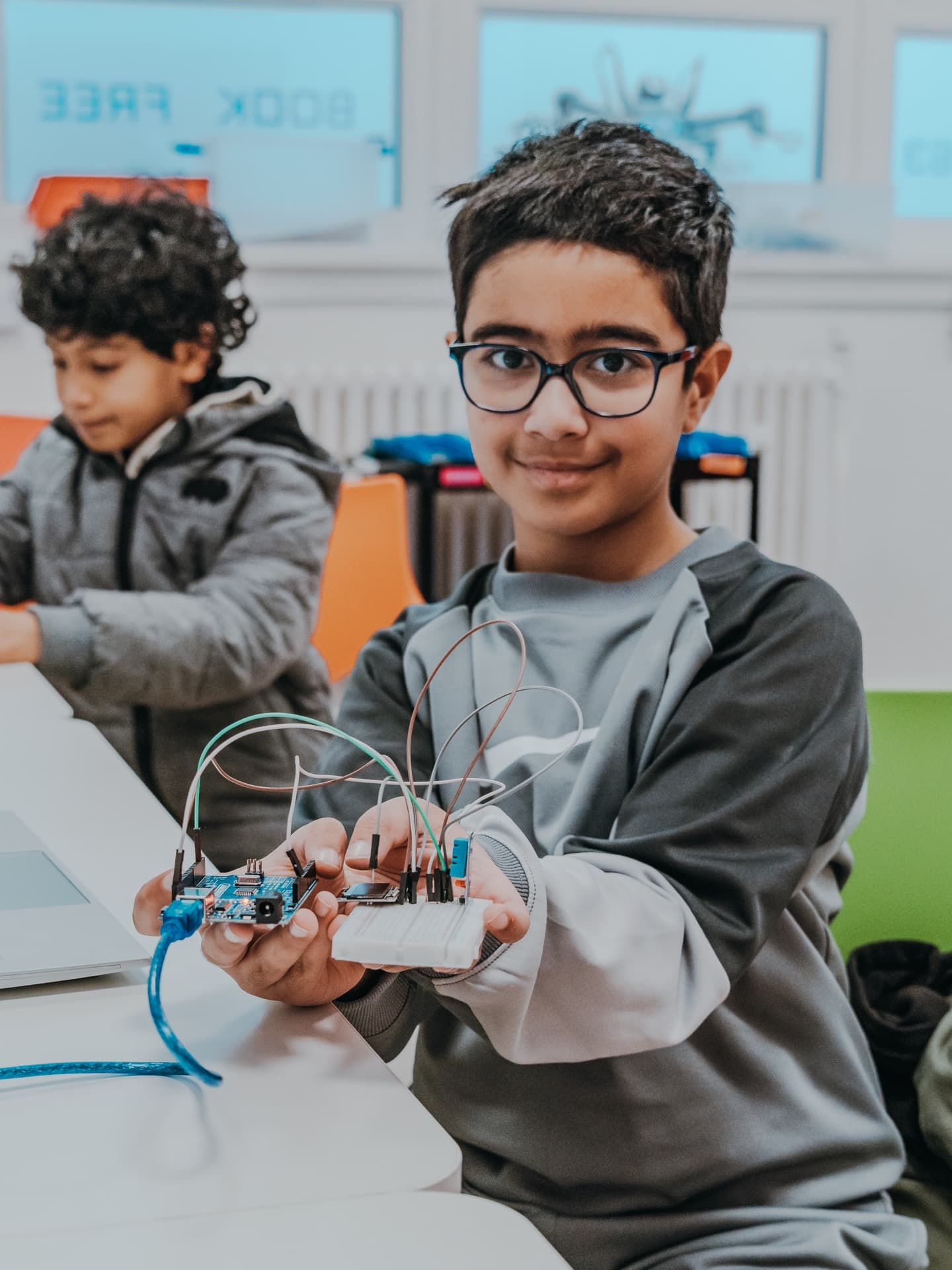Student proudly holding up a completed electronics project