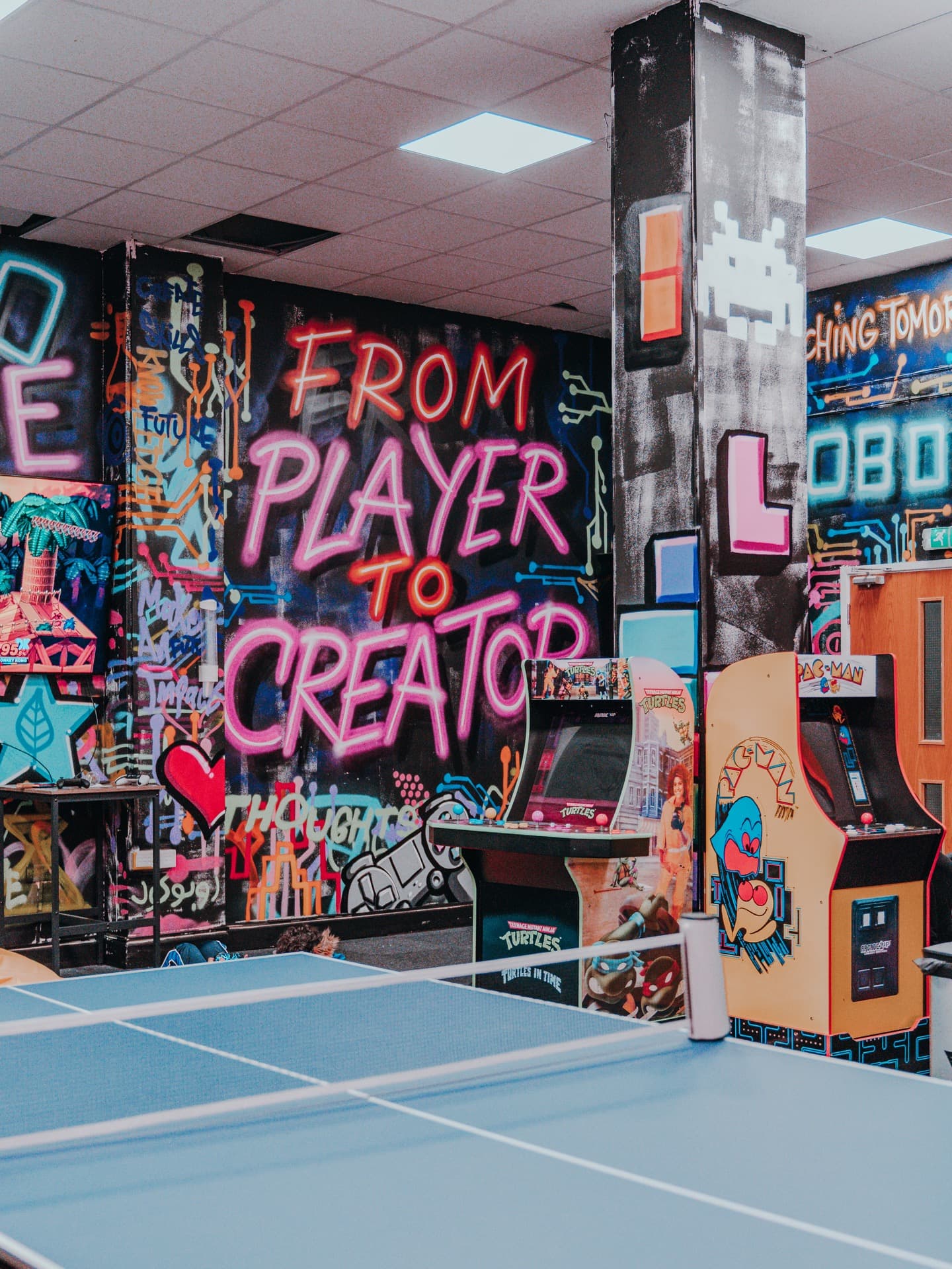 Inside the Robocode centre with arcade games, mural and activity areas