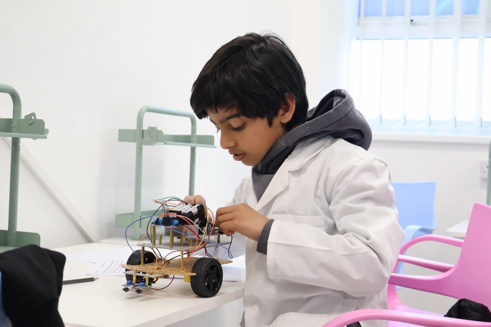 Instructor and student examining a completed robot car at Robocode